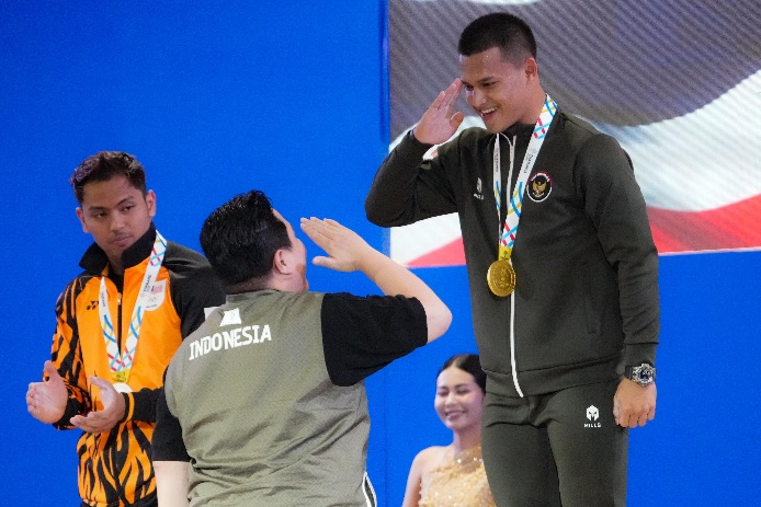 Lifter Rizki Juniansyah kembali mempersembahkan medali emas dan pecahkan rekor terwujud saat turun di kelas 79 kg putra SEA Games 2025 Thailand.(Sumber Foto: Fajar/kemenpora.go.id)